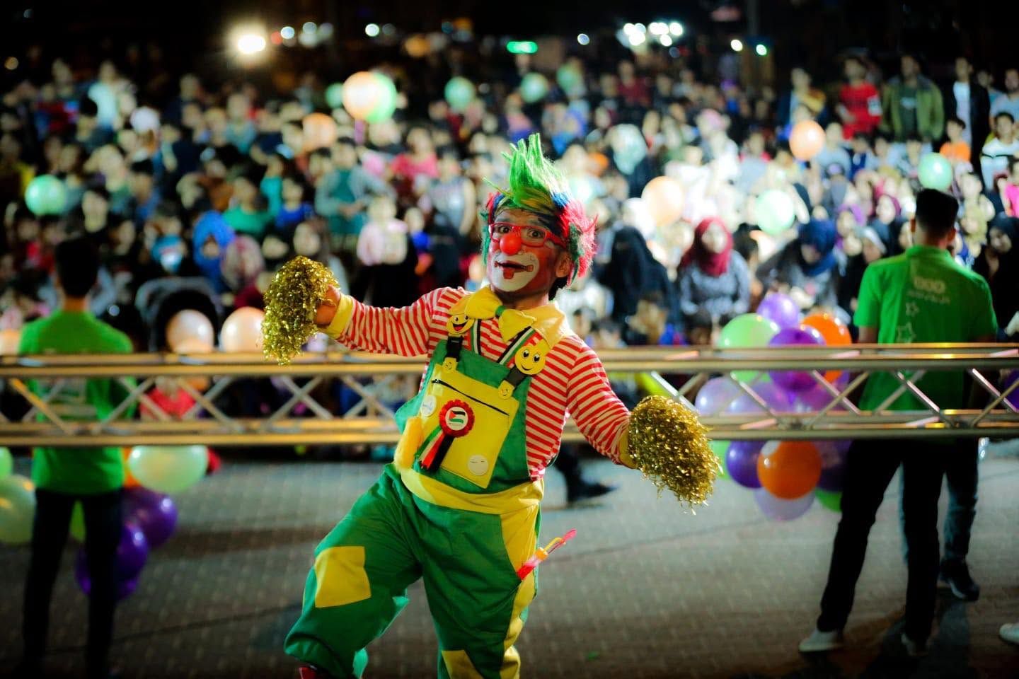 Family festival night: a clown show in front of a packed square